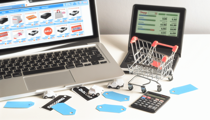 alt_text: Organized workspace with a laptop on shopping sites, shopping cart, discount tags, and calculator.