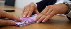 Osoba trzyma kartę kredytową nad kalkulatorem podczas analizowania warunków pożyczki.
