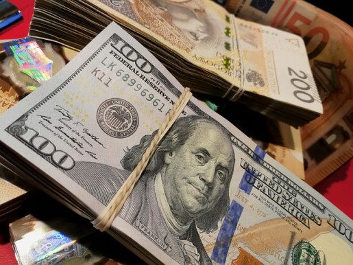 Stos monet i banknotów symbolizujący kwestie finansowe związane z pożyczkami na zakup samochodu.